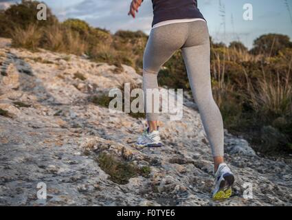 Young woman running uphill, vue arrière, low section Banque D'Images