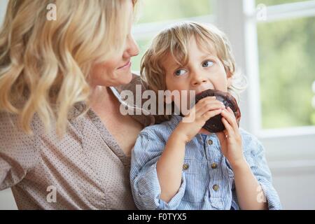 Muffin chocolat coin jeune garçon tandis que sa mère regarde sur Banque D'Images