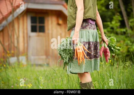 Portrait de femme portant des légumes dans le champ Banque D'Images