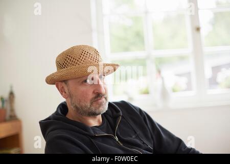 Portrait of mature adult man wearing straw hat, looking at camera Banque D'Images