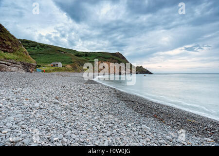 La tombée de la nuit sur la plage de galets à Millook Haven près de Bude sur la côte nord des Cornouailles Banque D'Images