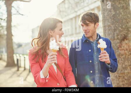 Couple eating ice cream cones tout en flânant le long Street, London, UK Banque D'Images