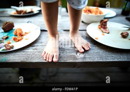 Boy standing on wooden table Banque D'Images