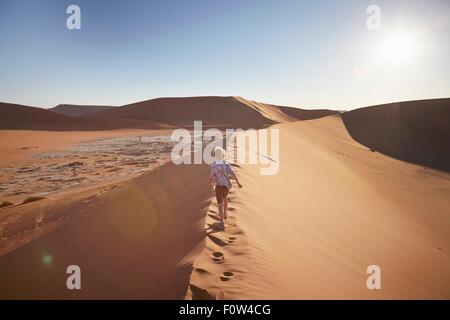 Boy walking on sand dune, Parc National Namib Naukluft, Désert du Namib, Sossusvlei, Dead Vlei, Afrique Banque D'Images