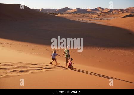 Mère et fils marche sur dune de sable, le Parc National Namib Naukluft, Désert du Namib, Sossusvlei, Dead Vlei, Afrique Banque D'Images