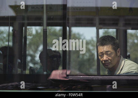 Beijing, Chine. 12 Aug, 2015. L'homme regarde à travers la fenêtre de l'autobus, Beijing, Chine. © Jiwei Han/ZUMA/Alamy Fil Live News Banque D'Images