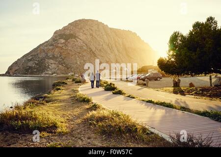 Tourist couple strolling vers Morro Bay Rock, Morro Bay, Californie, USA Banque D'Images