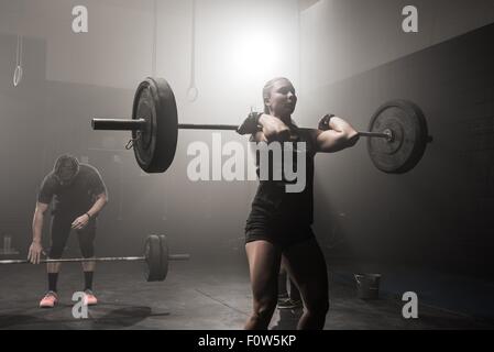 Jeune femme barbell levage Banque D'Images