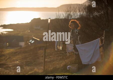 Woman hanging out lave dans jardin, Tokavaig, île de Skye, Écosse Banque D'Images