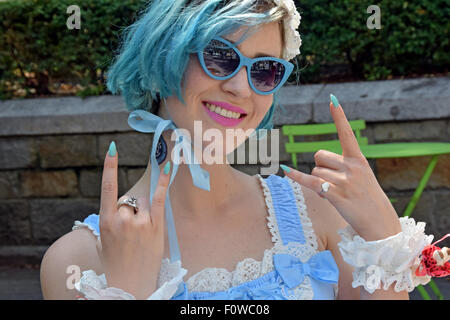 Un artiste habillé en bleu clair avec des cheveux bleus et fingrer les clous, à Union Square Park à New York City Banque D'Images