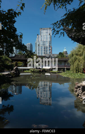 Reflet de hi-rise buinding dans l'eau immobile du Dr. Sun Yat-Sen Classical Chinese Garden, Vancouver Banque D'Images