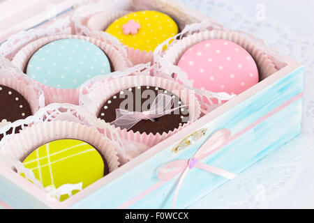 Les cookies de sucre coloré. Focus sélectif. La boîte en bois est peint en bleu clair et décoré avec un ruban de satin rose pâle Banque D'Images