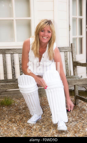 Woman putting sur ses jambières à l'extérieur du pavillon avant va agir dans un match de cricket chers Banque D'Images