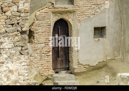 Unique habitation taillée dans la roche avec terrasse en bois dans un paysage montagneux présente des techniques architecturales anciennes Banque D'Images