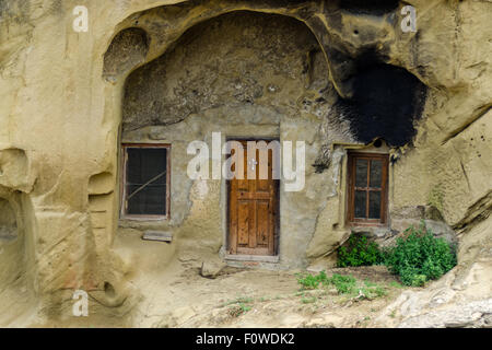 Unique habitation taillée dans la roche avec terrasse en bois dans un paysage montagneux présente des techniques architecturales anciennes Banque D'Images