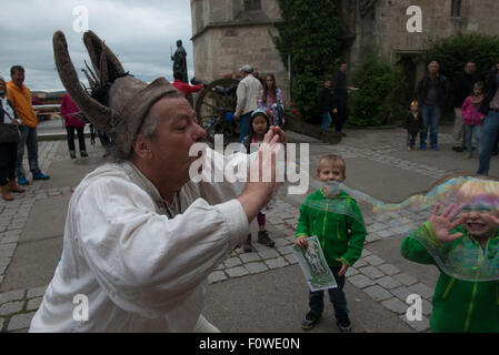 Un artiste de rue souffle des bulles de savon géantes pour amuser les enfants au Château de Hohenzollern, Bade-Wurtemberg, Allemagne Banque D'Images