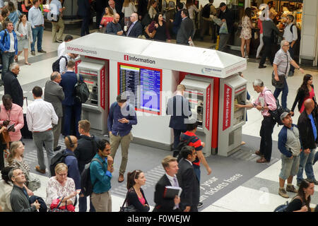 Les banlieusards de l'heure de pointe par l'achat de billets en utilisant les distributeurs de billets dans le hall de la gare de Liverpool Street. Banque D'Images