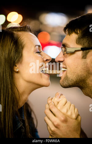 Jeune couple de manger ensemble un morceau de chocolat - dans la rue la nuit Banque D'Images