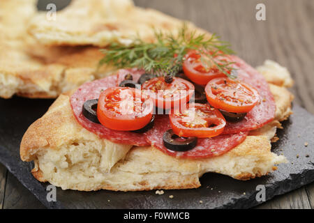 Sandwich avec du pain pita de salami et de légumes sur la table en bois Banque D'Images