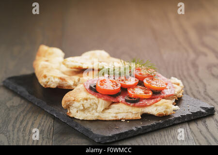 Sandwich avec du pain pita de salami et de légumes sur la table en bois Banque D'Images