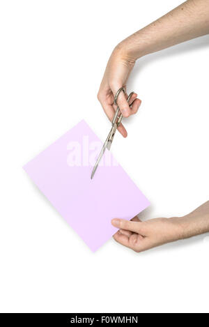 Une femme coupe une feuille de papier mauve à l'aide de ciseaux métalliques, isolé sur fond blanc Banque D'Images