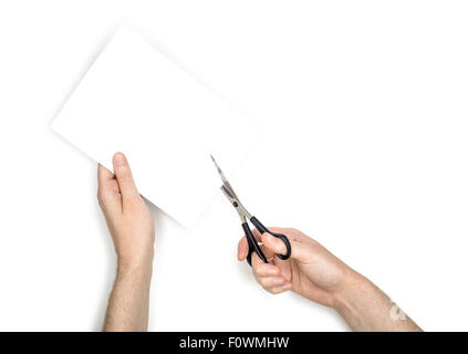 Une femme est couper une feuille de papier blanc à l'aide de ciseaux métalliques, isolé sur fond blanc Banque D'Images