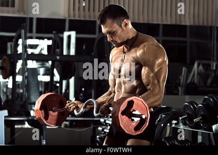 Puissance très sportif bodybuilder , exécuter l'exercice avec avec le poids, en salle de sport Banque D'Images