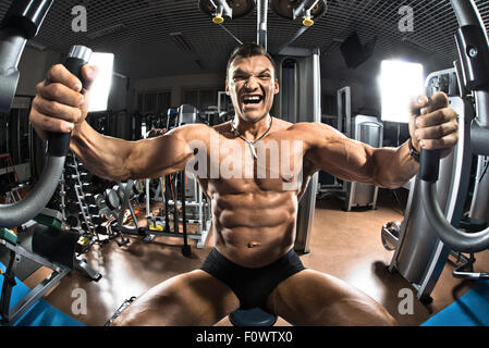 Bodybuilder , très intense guy exécuter l'exercice sur les appareils de fitness, gym en Machine Papillon Banque D'Images