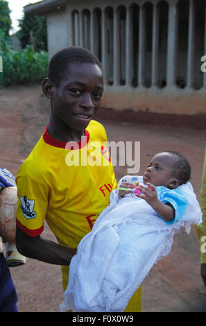 Garçon nigérian avec un bébé debout pour un portrait que j'au Nigeria Banque D'Images