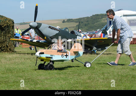 Shoreham Airshow 2015. Enfant qui est poussé par des profils dans la Luftwaffe allemande jouet moi109 avion de chasse Banque D'Images