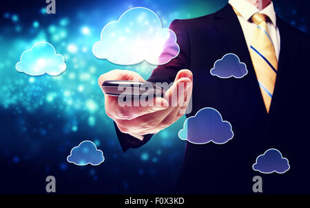 Business man holding a mobile phone with cloud concept connexion Banque D'Images