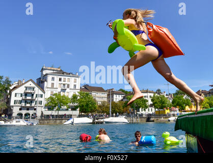 Zurich, Suisse. Le 22 août, 2015. Une jeune femme est de sauter dans la rivière Limmat Zurich cool à la dérive vers le bas 2km à travers la ville. Le temps ensoleillé et les températures chaudes à la Zurich's 'traditionnelle' ('SLimmatschwimmen wim en bas de la rivière Limmat') a attiré 4500 nageurs qui, équipés de tortues en caoutchouc et d'autres dispositifs flottants de fantaisie, apprécié à la dérive le fleuve grâce à Zurich. Crédit : Erik Tham/Alamy Live News Banque D'Images