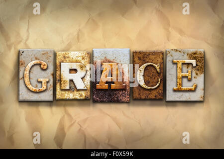 Le mot 'grace' écrit en métal rouillé typo sur un type de papier fond émietté. Banque D'Images