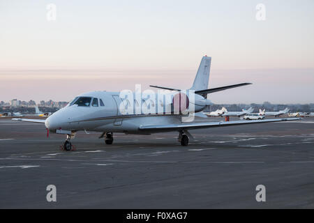 L'entreprise privée jet avion stationné sur le tarmac de l'aéroport - lever du soleil sur l'arrière-plan Banque D'Images