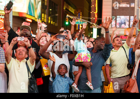 New York, USA. Août 21, 2015. Les touristes vague comme ils se voient eux-mêmes à partir d'un affichage numérique géant à Times Square, New York, États-Unis, le 21 août 2015. Credit : Muzi Li/Xinhua/Alamy Live News Banque D'Images