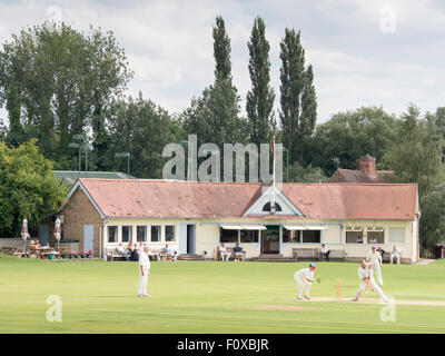 Club de Cricket de Sudbury : les joueurs et spectateurs profiter d'un jeu de cricket sur un après-midi d'été. Banque D'Images
