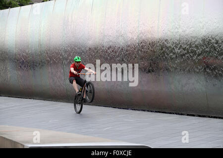 Stunt cyclist en face de la pointe de l'acier sculpture à la gare ferroviaire de Sheffield Banque D'Images