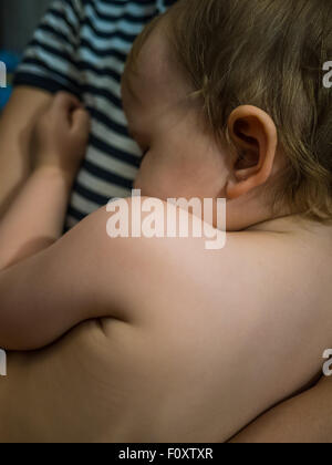 Dormir mignon petit garçon sur les mains des mères Banque D'Images