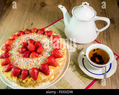 Gâteau au miel avec fraise sur le dessus et d'un plateau de table en bois Banque D'Images