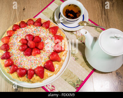 Gâteau au miel avec fraise sur le dessus et d'un plateau de table en bois Banque D'Images