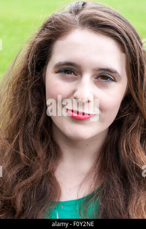 Portrait d'une jeune femme avec des yeux noisette, et des cheveux bruns bouclés. Banque D'Images