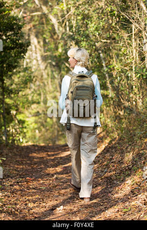 Vue arrière de la haute female hiker walking in forest Banque D'Images