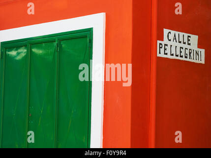 Mur de couleur rouge vif et des volets verts Burano Lagune de Venise Vénétie Italie Europe Banque D'Images