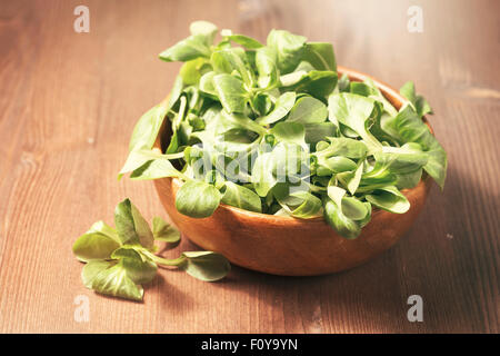 Salade de maïs frais dans un bol en bois sur fond de bois Banque D'Images