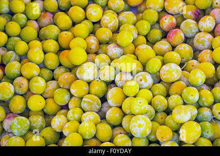 Une pile de prunes jaunes à la vente à un marché Banque D'Images