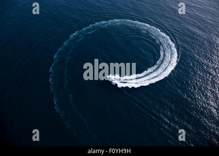 Image d'une petite embarcation à moteur d'un virage en forme d'un tourbillon au milieu de la mer sur une journée ensoleillée Banque D'Images