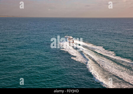 Petit bateau de vitesse voile à travers un appel dans la soirée de la mer Banque D'Images