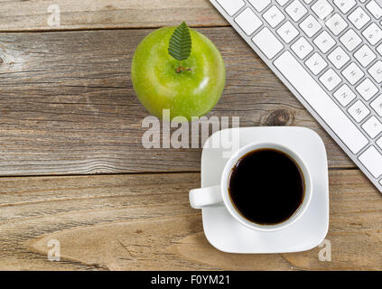 Vue de dessus de la pomme verte, selective focus on top leaf et café, café noir avec clavier ordinateur partielle sur bois rustique. Banque D'Images