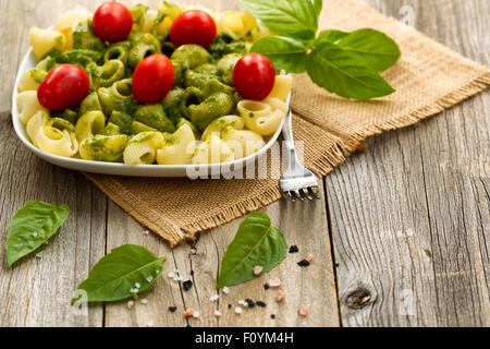 Avec le Pesto au basilic pâtes en forme de coquillage et de tomates cerises. Selective focus sur la partie avant de la plaque. Banque D'Images