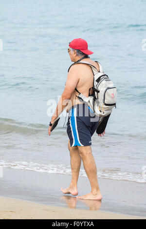 Man Walking on beach in Spain with Baseball Cap sur l'arrière vers l'avant Banque D'Images